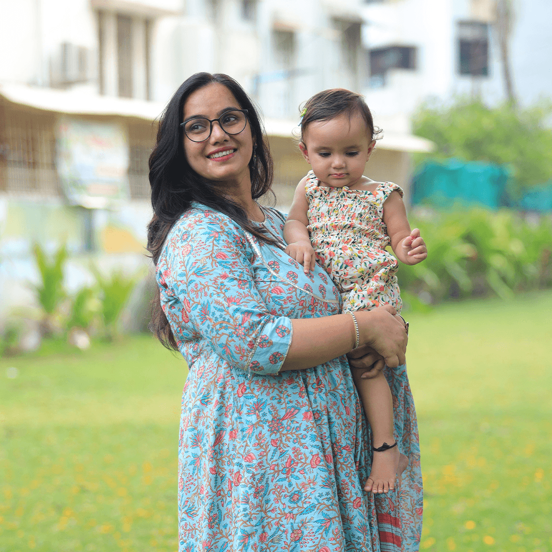 Mother smiling while holding her baby outdoors