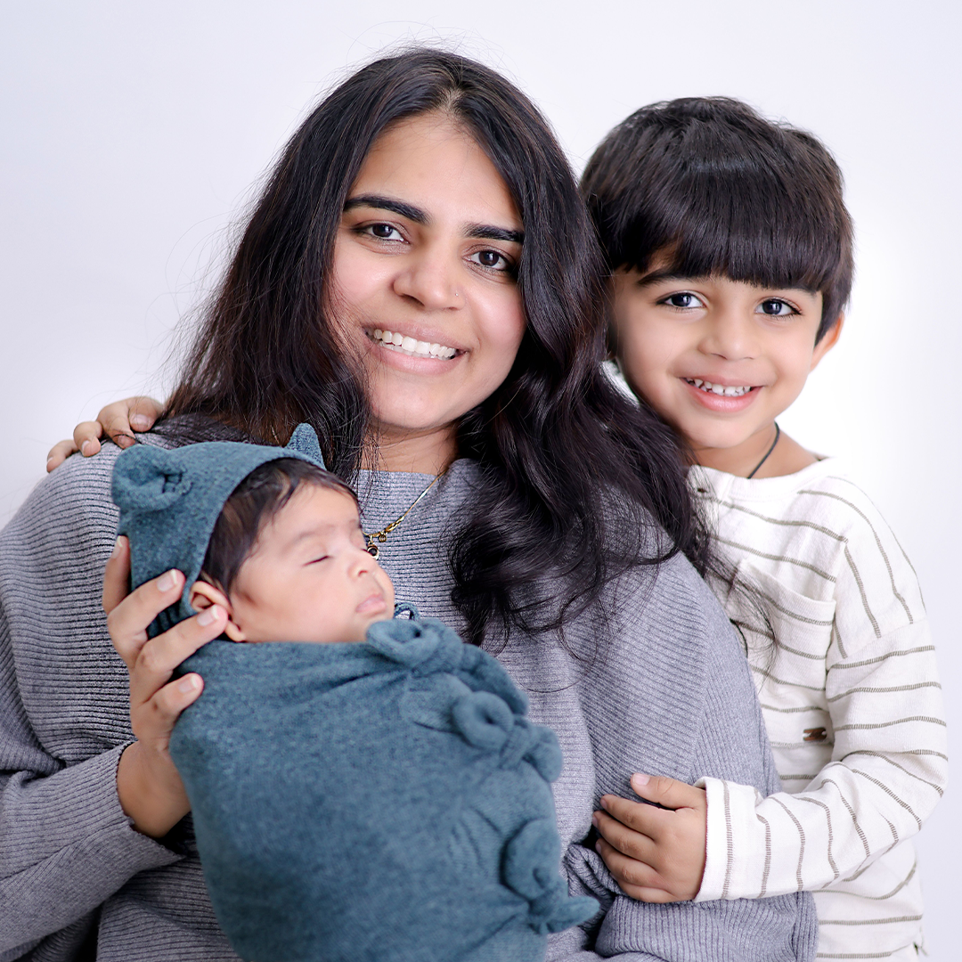 Mother with her baby and young son smiling together