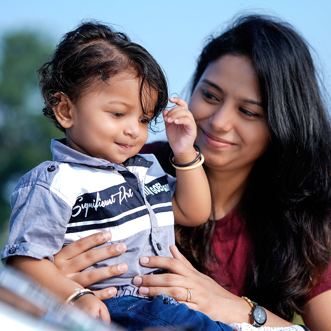 Mother playing with her toddler son outdoors