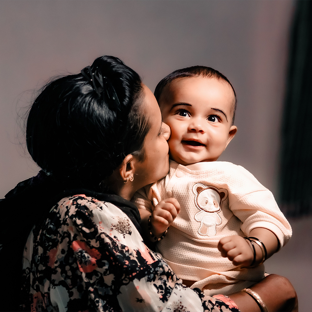 Mother kissing her smiling baby