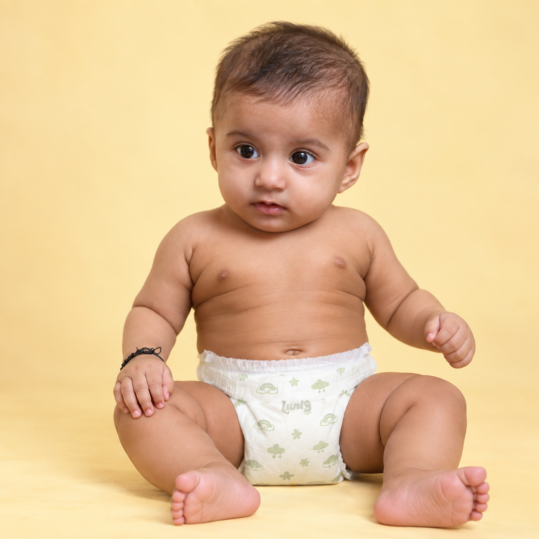 Mother smiling at her baby on the sofa, baby wearing a Lumi9 diaper